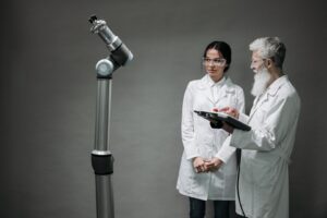 Zwei Forschende neben einem kollaborativen Roboterarm im Labor