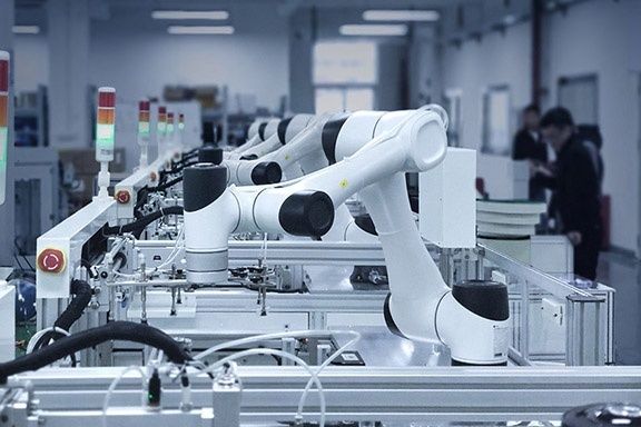 Weiße Cobots arbeiten an einer automatisierten Montagelinie in der Fabrik